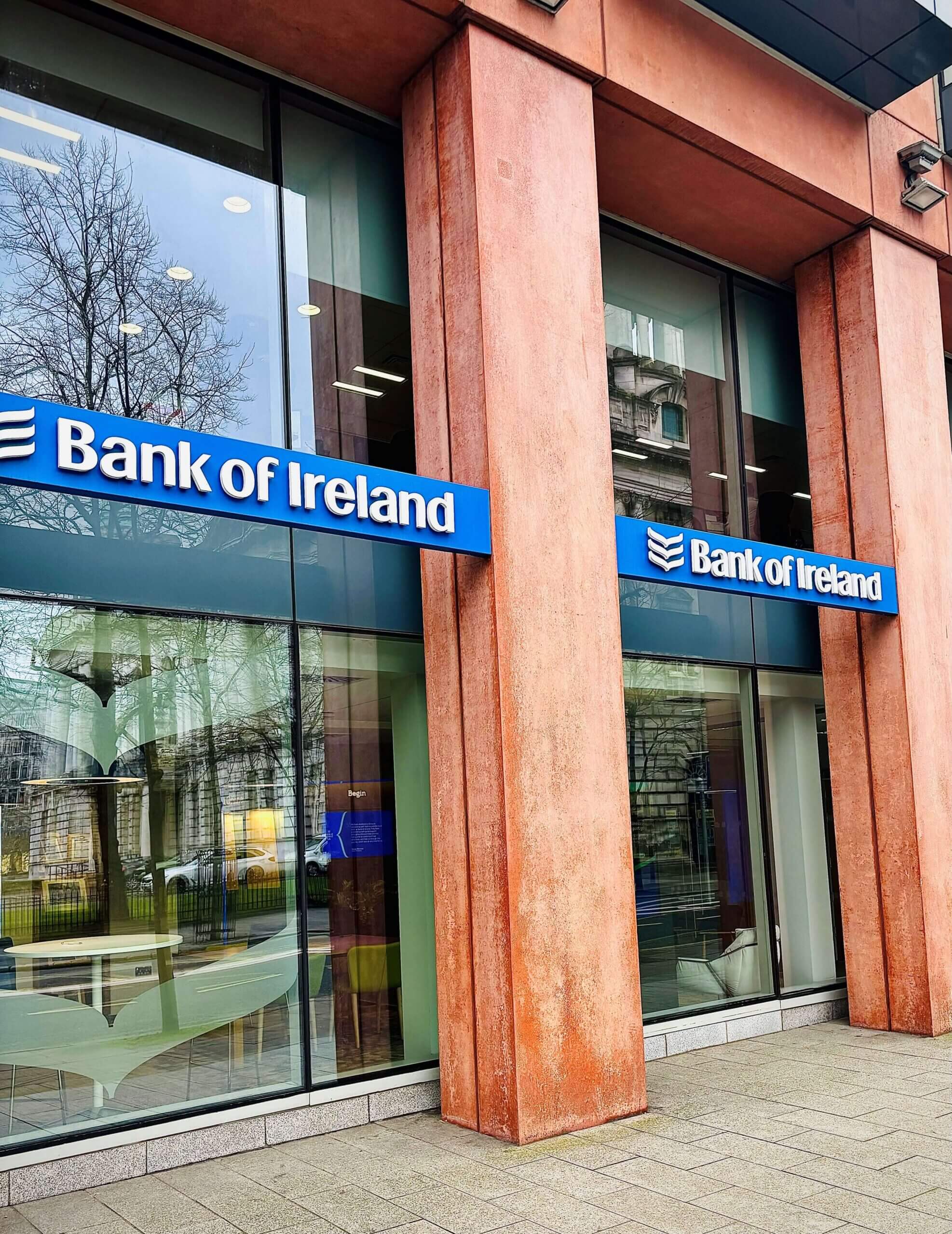 A branch of the Bank of Ireland with glass windows, blue and white signage.