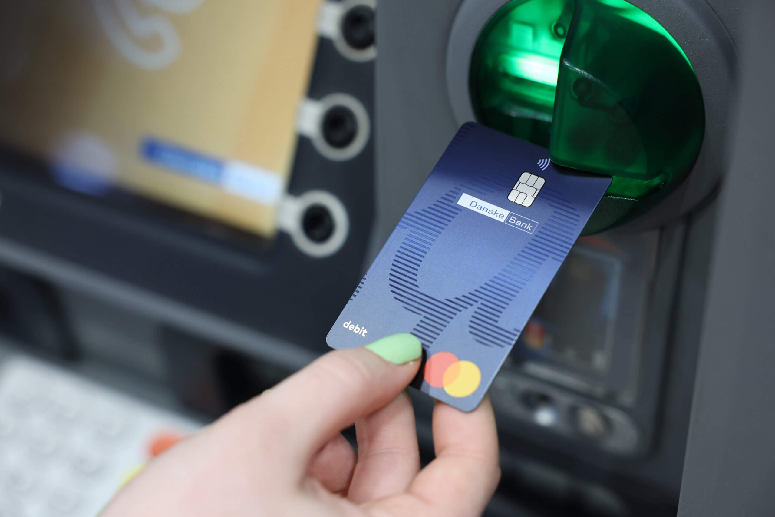 A blue Danske Bank debit card being put into an ATM